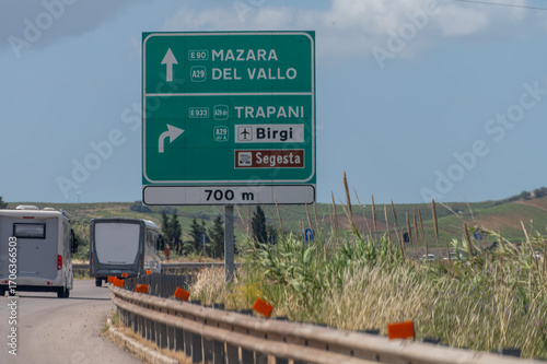Road transportation on Sicily, Italy, green signs guide to cities by highways, blue signs by city roads. Arrows, distances, and exits help travelers navigate Sicily