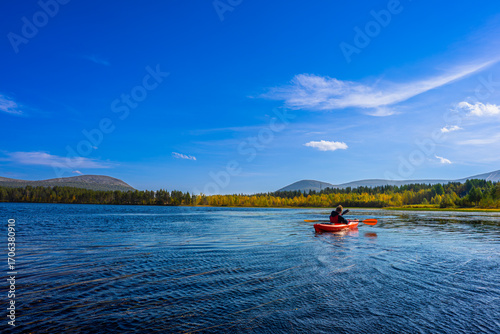 Boy Kayaking on Lake with View of Ylläs Fells, Autumn Lapland Finland