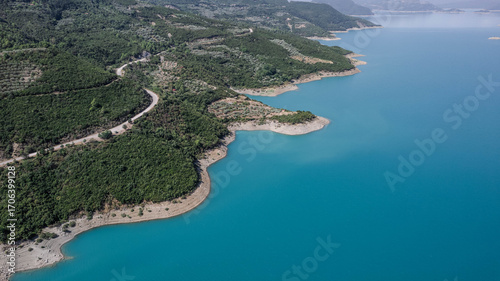 Wallpaper Mural Aerial view of turquoise blue lake in Albania with winding shoreline green hills and mountain backdrop scenic landscape and travel photography spot Torontodigital.ca