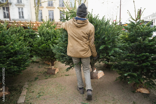 Fotografie The man bought and dragged a Christmas tree home