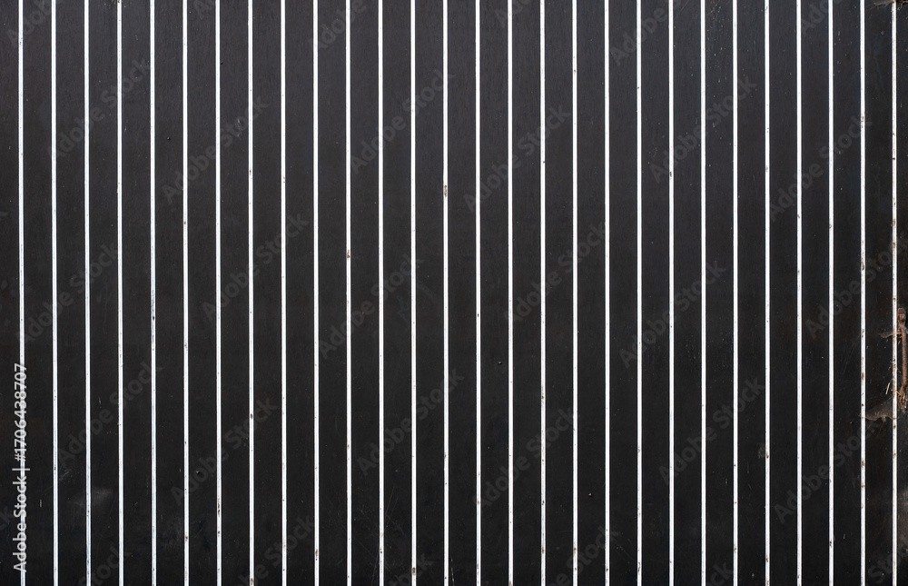 Obraz premium Old worn door of a barn with black and white stripes in Sint Laureins, East Flanders, Belgium
