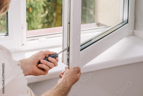 Foto A repairman is installing a PVC window frame in a residential apartment