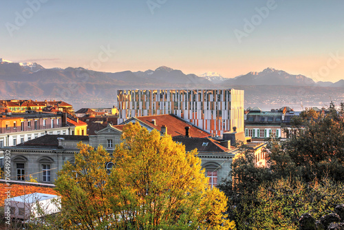 Sunset over Lausanne, Switzerland, with rennovated Lausanne Opera House - the modern scene cage built on top of the old building following the design of Devanthéry & Lamunière against the Alps