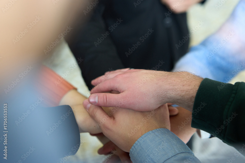 Fototapeta premium A top view of business people joining hands in a circle, symbolizing unity, collaboration, and shared success in the workplace