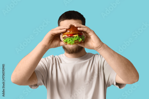 Young man with tasty burger...
