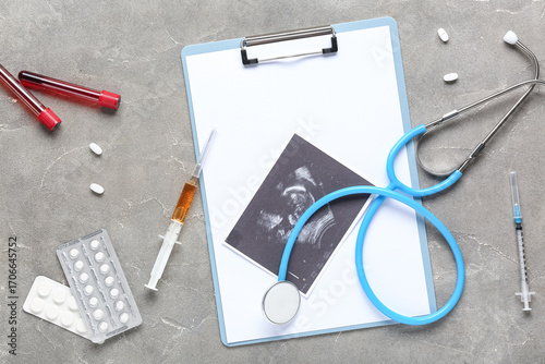Sonogram image with medical supplies on grunge background. IVF concept