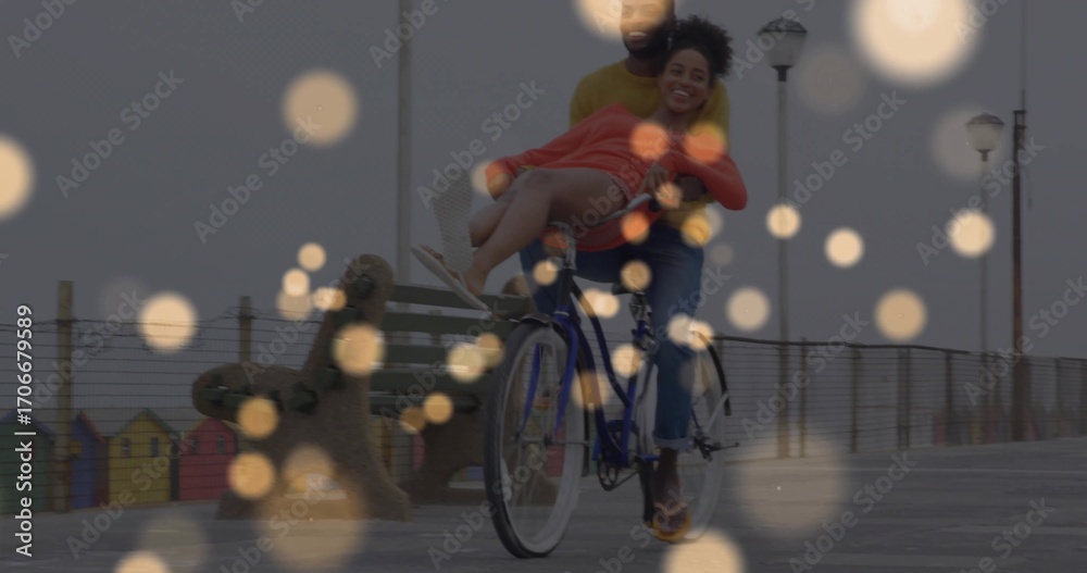 Naklejka premium Pedaling couple embracing while riding seaside pier with bicycle bench huts railing and lampposts