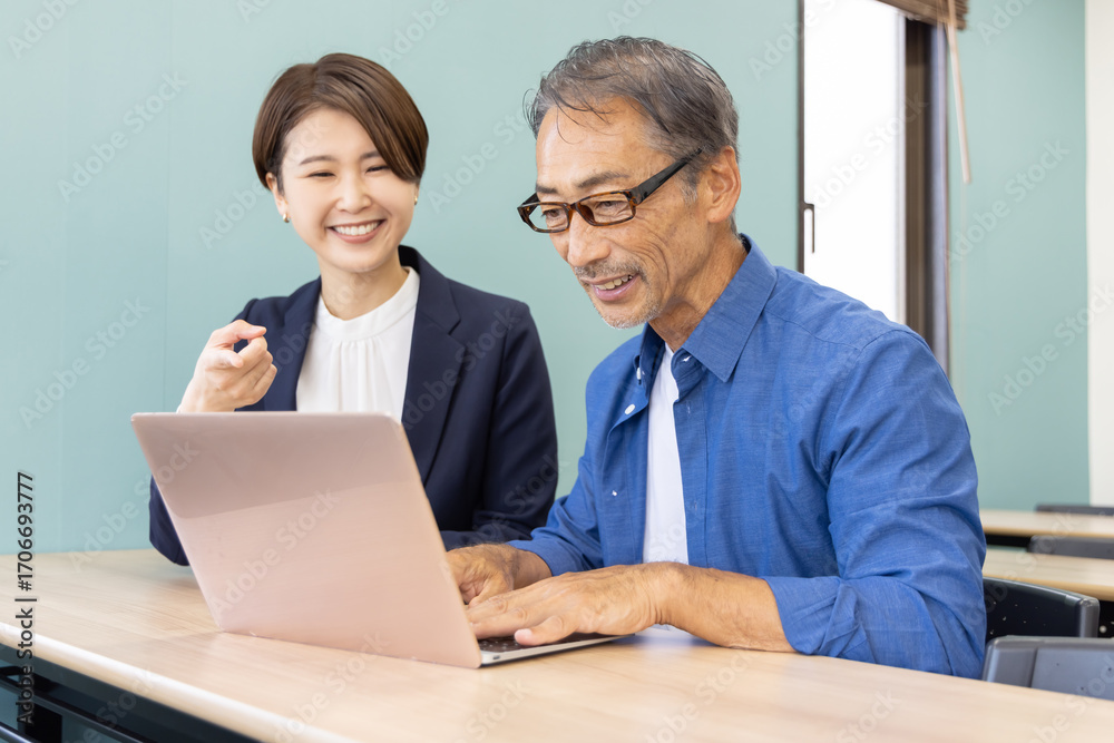 Fototapeta premium パソコン教室に通うシニアと教える講師
