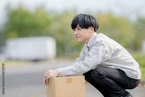 しゃがむ作業服男性