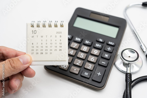 Medical Appointment Concept with 2025 October Calendar, Calculator and Stethoscope. symbolizing healthcare appointments, medical checkups, and patient consultation scheduling.