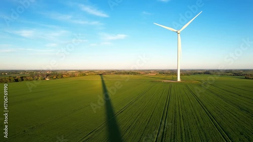 Wind turbine shadow stretching farmland cinematic UHD renewable green energy stock video. windfarm silhouette field movie ultra high definition sustainable power footage.