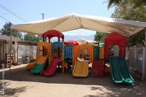 Wallpaper Mural Colorful outdoor children's playground with slides and climbing frames under a shade canopy Torontodigital.ca