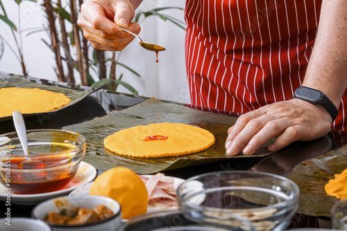 Sprinkling annatto oil on corn dough for hallacas