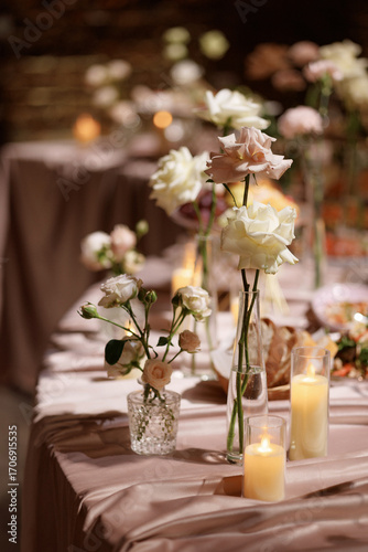 Photos Wedding banquet table decorated with flowers, candles and food in festive hall with dark background