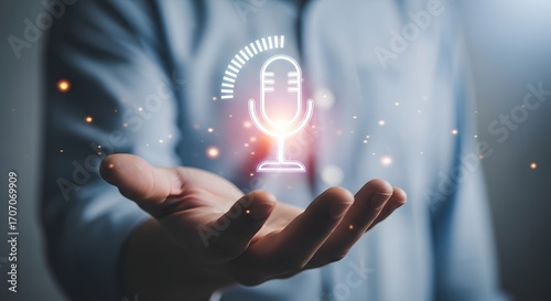 A person's hand cradles a glowing microphone icon, representing audio recording.