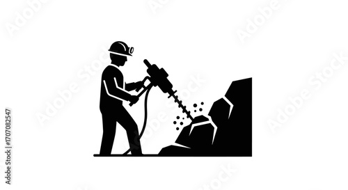 Silhouette of a miner drilling into rock with a jackhammer, wearing a helmet with a light.
