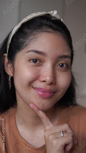 Close up shot of a young Asian woman with bare face before applying make up, healthy skin.