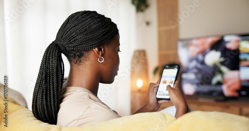 Fotografija Black woman, phone screen and planning holiday on sofa for online getaway or accommodation in home