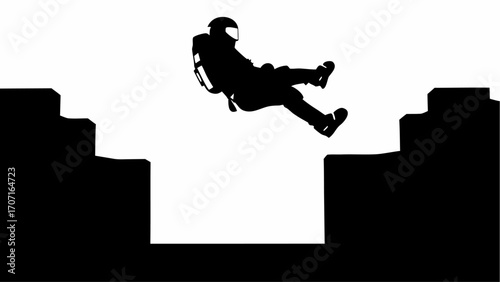 Silhouette of a person in a helmet and gear jumping between two cliffs in a black and white landscape