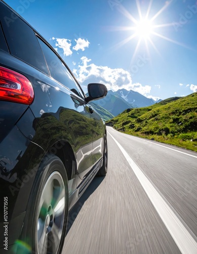 Driving a black car along a road with mountains under a bright sun, showcasing a scenic drive in nature