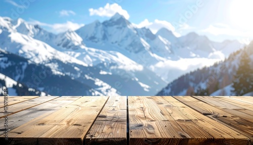 Rustic empty wooden table foreground with a beautifully blurred background of a sunlit, snow-covered mountain range in winter