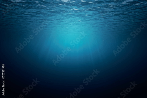 An underwater view looking up towards the sun, with light rays filtering through the deep blue ocean water.