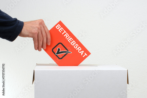 Betriebsrat - Hand wirft Stimmzettel in Wahlurne