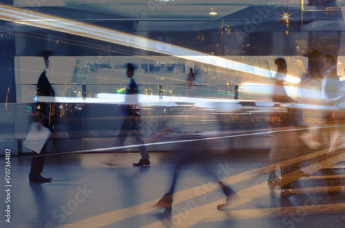 business people crowd walking commuting in the city, lights and motion blur abstract	