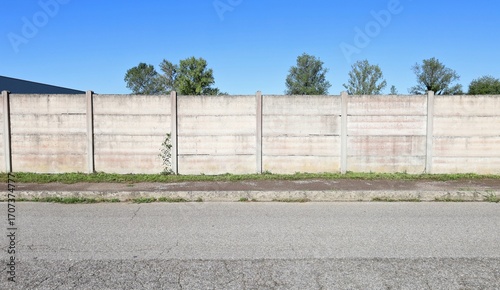 Wallpaper Mural Concrete precast compound wall at the road side. Sidewalk and road in front, trees and sky on behind. Background for copy space Torontodigital.ca