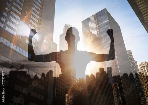 Fotografija double-exposure of a silhouetted figure with raised arms against a modern city s