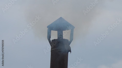 Smoke from a small chimney against a cloudy sky. A small rural bathhouse is being heated