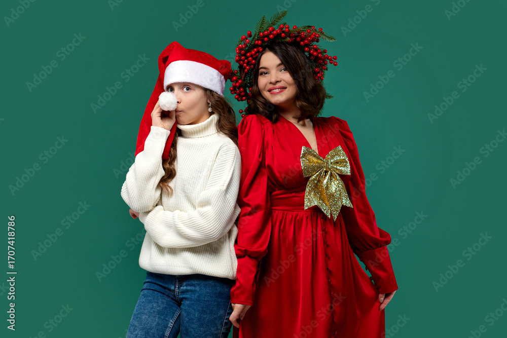 Fototapeta premium Mum in red dress with gold bow and teen daughter. Christmas card with New Year's greetings