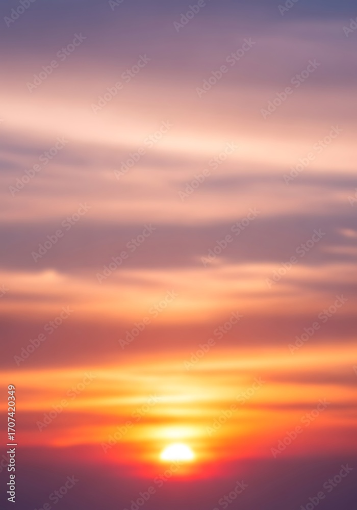 Fototapeta premium Vibrant sunrise illuminating gradient sky with blurred cloud formations