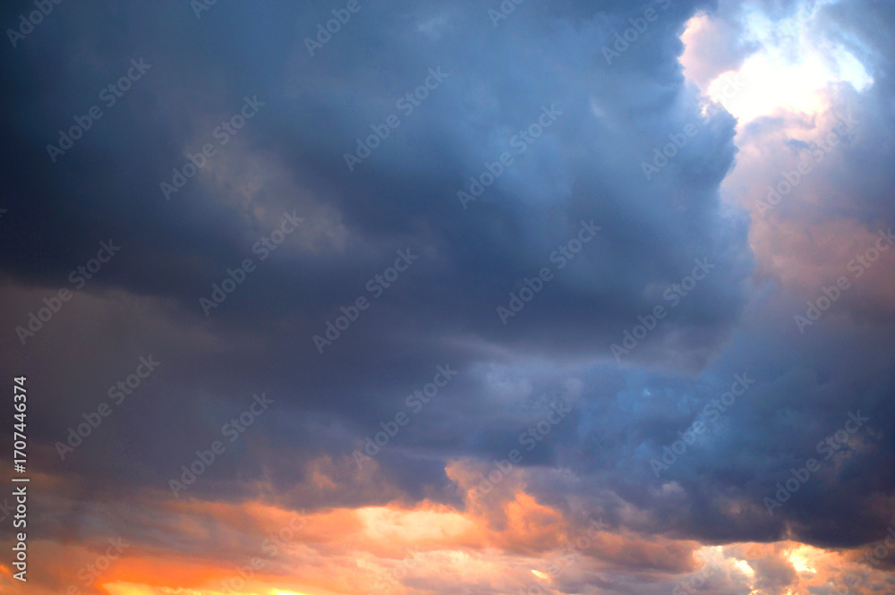 Obraz premium Colorful sunset sky with moody clouds and golden sun