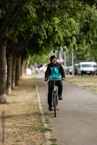 Wallpaper Mural Delivery man riding bicycle in city park delivering food Torontodigital.ca