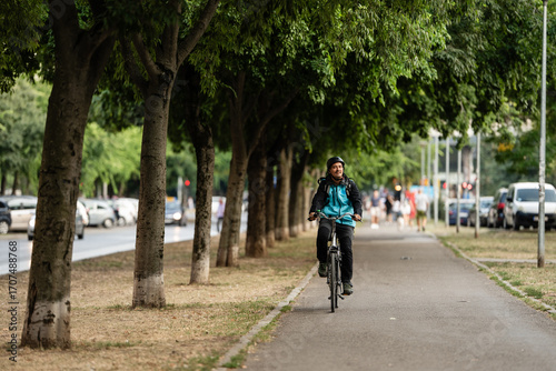 Wallpaper Mural Delivery man riding bicycle in city park delivering food Torontodigital.ca
