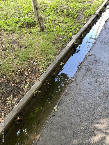 Dirty water runoff in a ditch on a private sidewalk