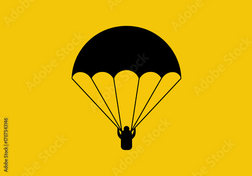 A black silhouette of a person parachuting against a yellow background