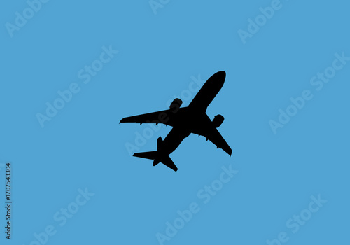 A black silhouette of an airplane ascends against a serene blue sky