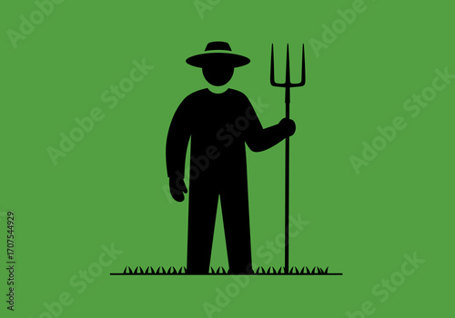 Farmer with pitchfork a stark black silhouette stands on green grass