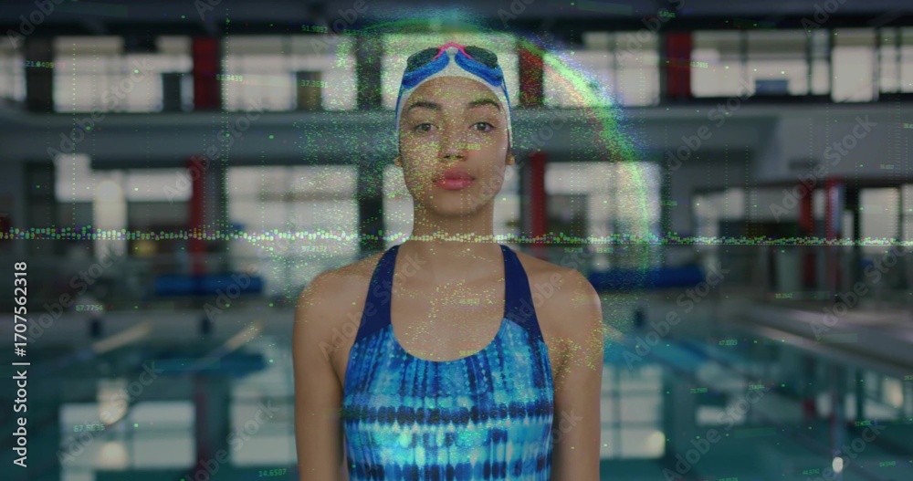 Fototapeta premium Standing woman wearing tie-dye swimsuit, swim cap at lap pool, with goggles and lane dividers