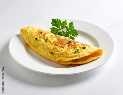 A folded omelette with a few chopped herbs and a parsley garnish, on a white plate with a soft shadow.