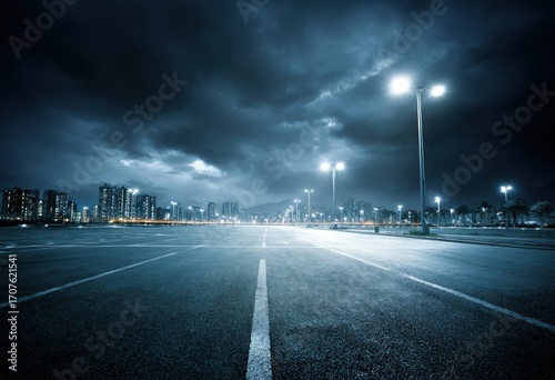 Fototapeta Naklejka Na Ścianę i Meble -  A deserted highway at night under a stormy sky, illuminated by streetlights, leads to distant city buildings