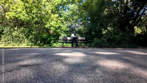 Wallpaper Mural Individual working remotely on a laptop while sitting on a park bench. Torontodigital.ca