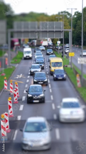 cars on an urban highway driving towards camera, building site