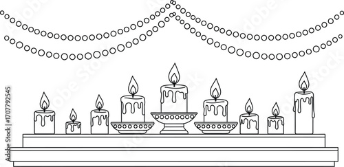 Row of lit candles on a mantelpiece with festive garland overhead