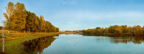 calm water of the lake and autumn trees create an atmosphere of tranquility
