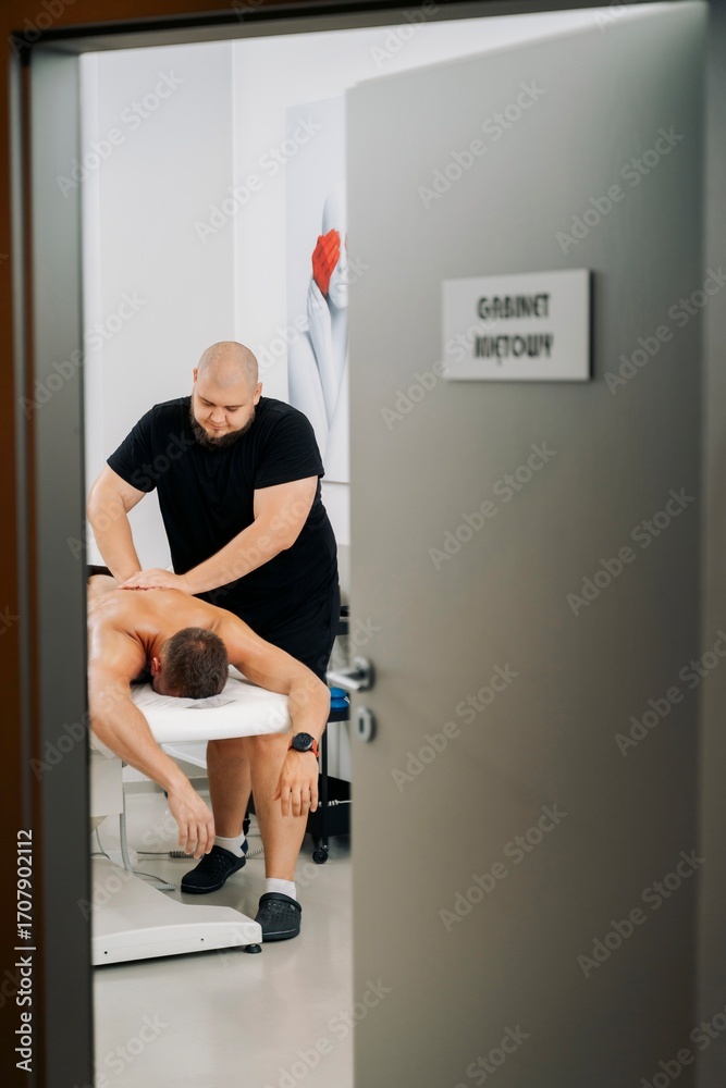Fototapeta premium Male client receiving therapeutic massage in clinic room
