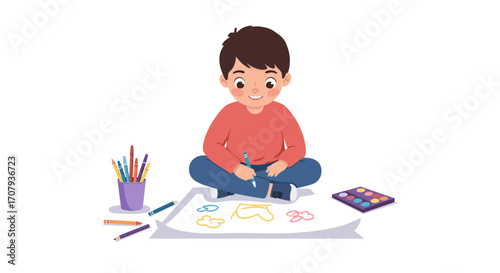 A young boy sits cross-legged on the floor, happily drawing on a large sheet of paper with crayons and paints.