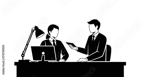 Two businesspeople seated at a desk, engaged in a discussion, possibly a presentation or review.